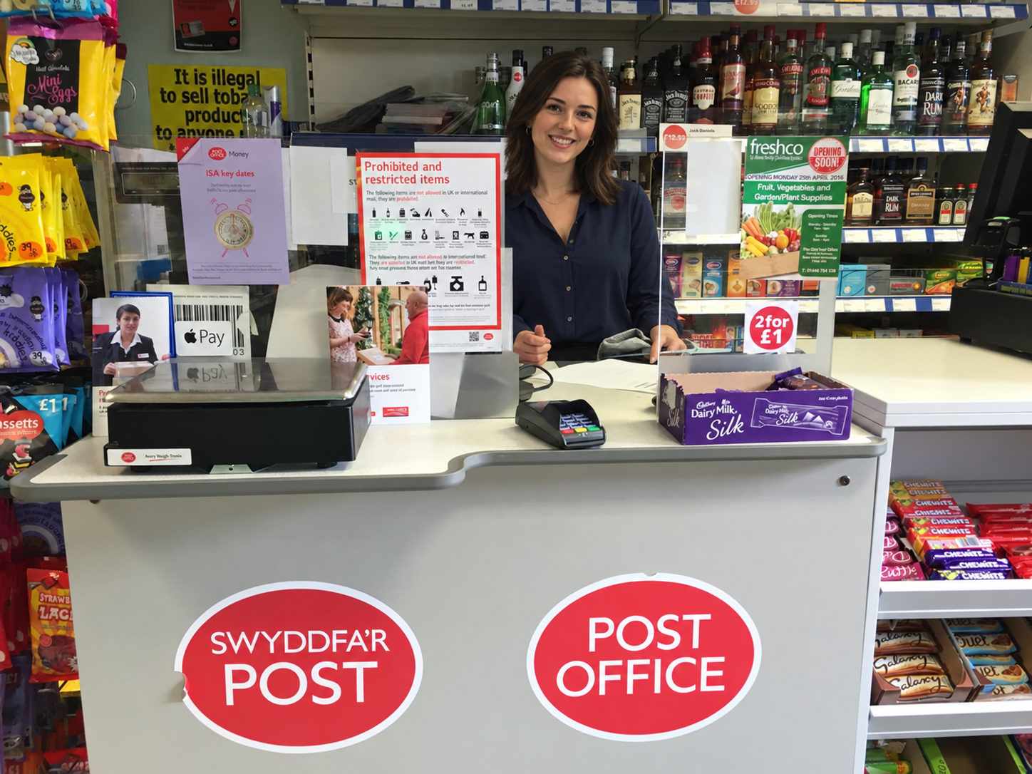 Illustrative edit of the shop’s Post Office counter with a fictional adult assistant.